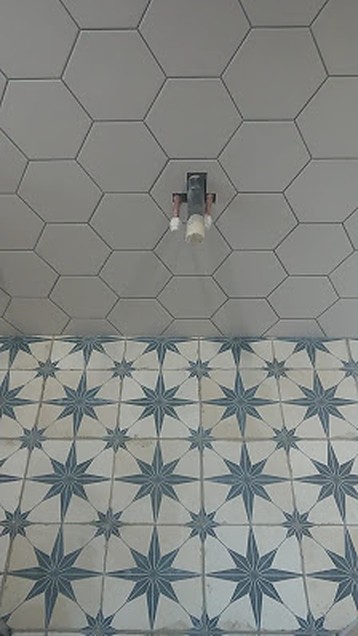 Hexagon wall tiling and patterned star-motif floor tiles in a bathroom