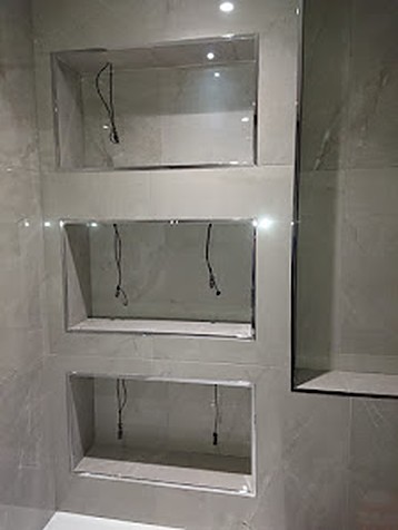 Recessed shower storage niches finished in tiled porcelain with integrated lighting